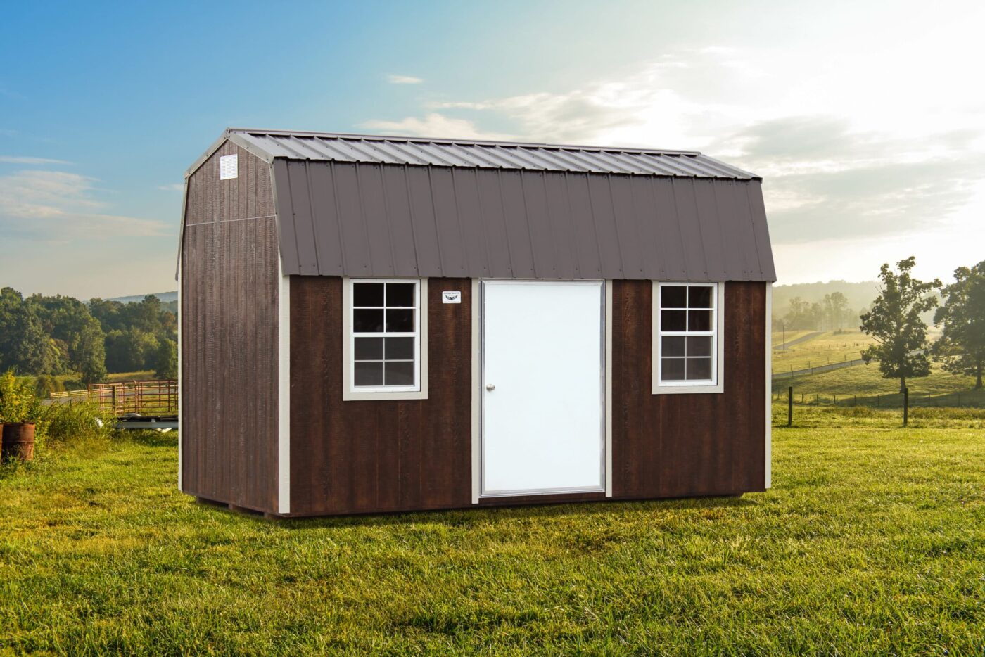 a brown portable barn shed with two windows, beige trim, a white door, and a grey metal roof for sale in imboden AR